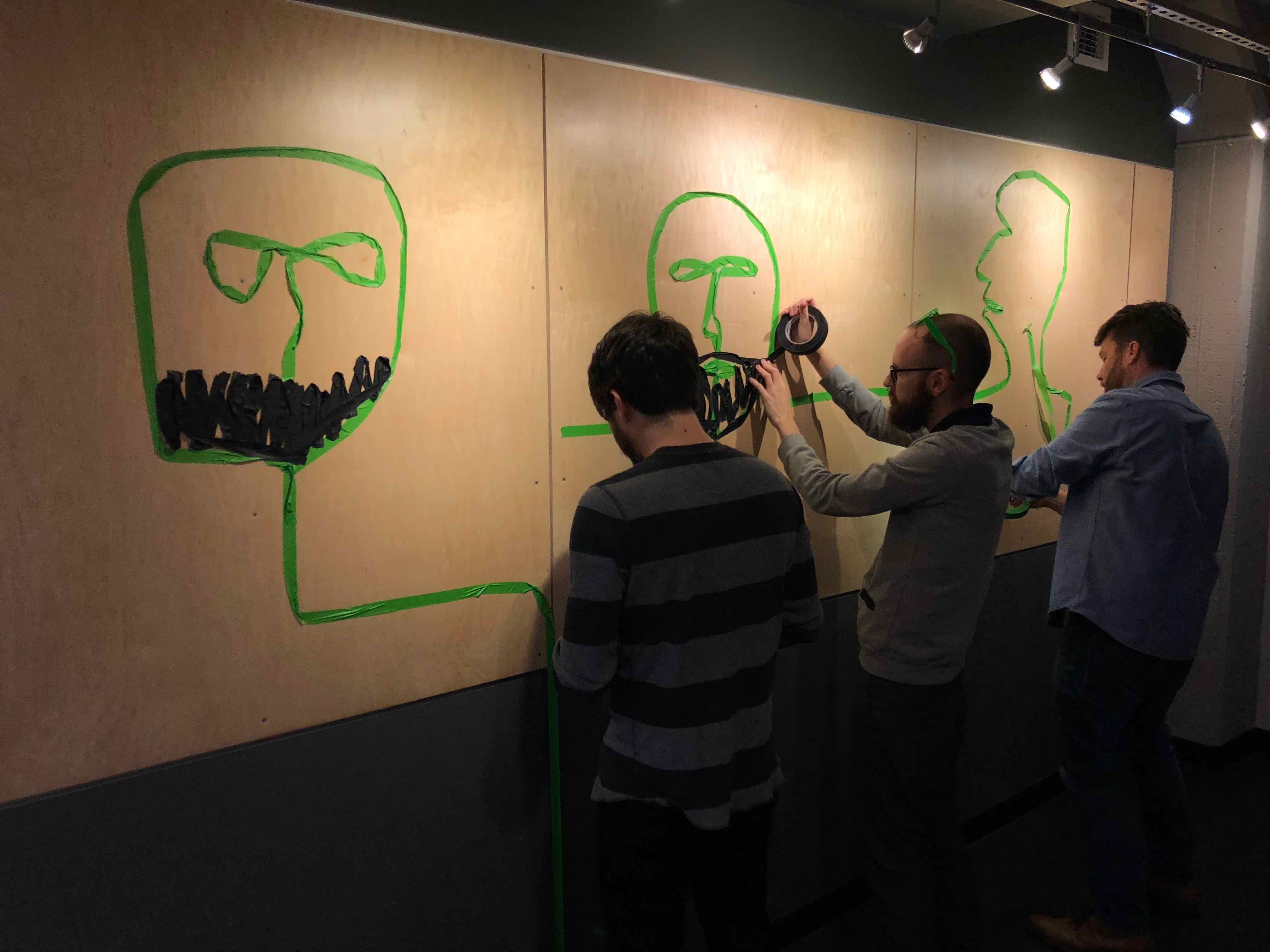 Masking tape self portraits taking shape.